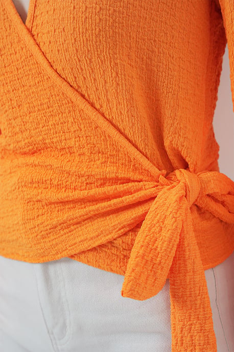 Strukturierte V-Ausschnitt-Bluse mit Pompons und Bindebandverschluss - Image 4