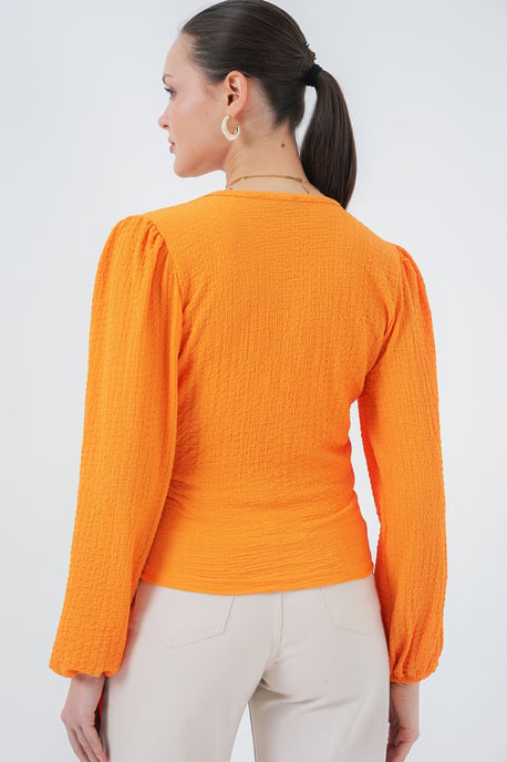 Strukturierte V-Ausschnitt-Bluse mit Pompons und Bindebandverschluss - Image 5